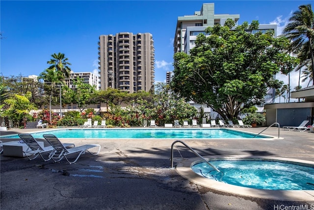 view of pool with a hot tub and a patio area