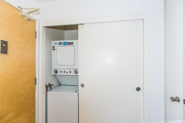 clothes washing area featuring stacked washer and clothes dryer