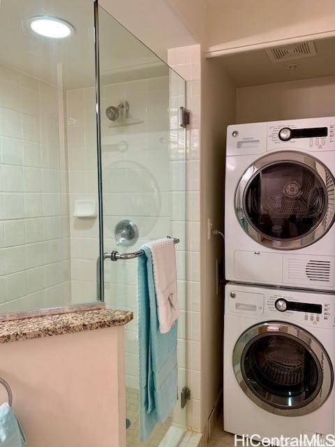 washroom featuring stacked washer / dryer