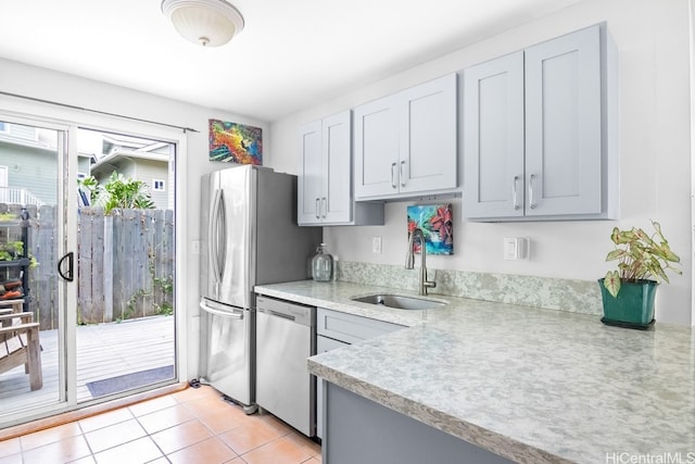 kitchen with gray cabinets, sink, appliances with stainless steel finishes, and light tile patterned floors