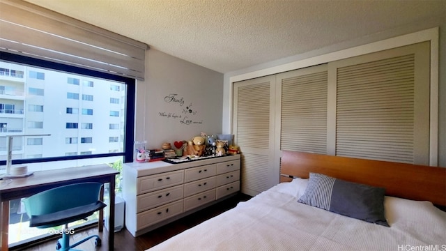 bedroom with a textured ceiling and dark hardwood / wood-style floors