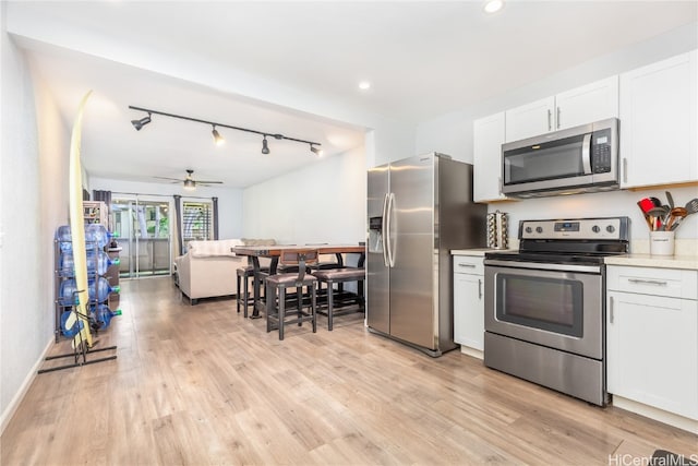 kitchen featuring appliances with stainless steel finishes, white cabinets, ceiling fan, and light hardwood / wood-style floors