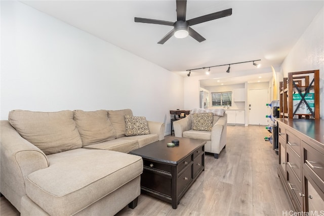 living room with light hardwood / wood-style flooring, track lighting, and ceiling fan