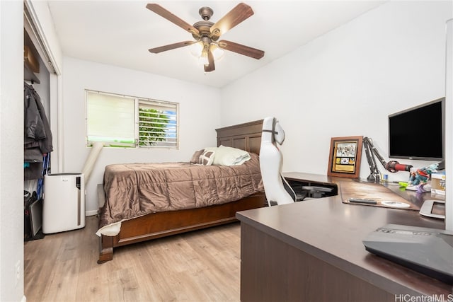 bedroom with a closet, light wood-type flooring, and ceiling fan