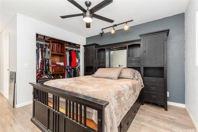 bedroom with a closet, light hardwood / wood-style floors, track lighting, and ceiling fan