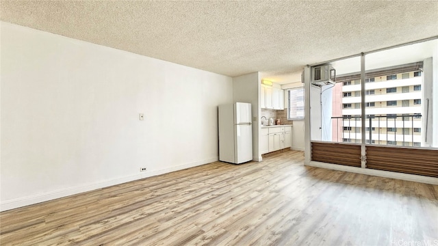 interior space with light hardwood / wood-style floors, a textured ceiling, and sink