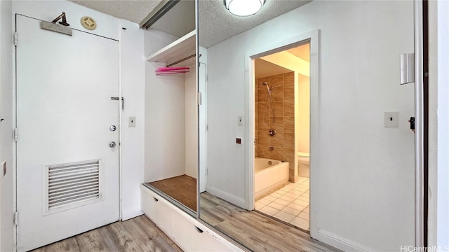 mudroom featuring a textured ceiling and light wood-type flooring