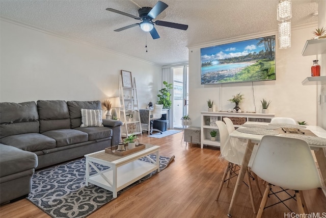 living room featuring ornamental molding, a textured ceiling, hardwood / wood-style flooring, and ceiling fan