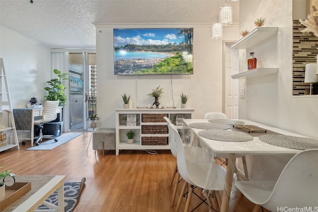 dining room featuring crown molding, a textured ceiling, and wood-type flooring