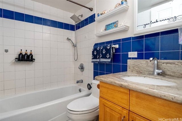 full bathroom with vanity, toilet, tile walls, and tiled shower / bath