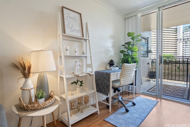 office space with ornamental molding, a textured ceiling, and hardwood / wood-style flooring