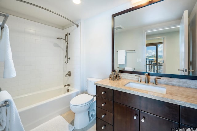 full bathroom with vanity, tiled shower / bath combo, and toilet