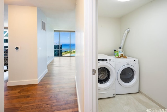 laundry room featuring washer and clothes dryer and light hardwood / wood-style flooring