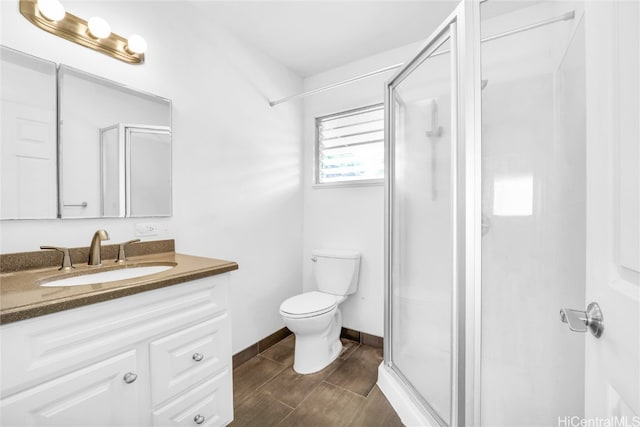 bathroom with vanity, a shower with shower door, and toilet