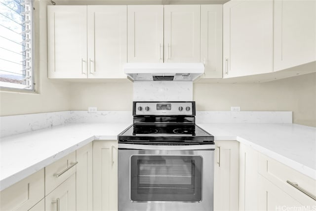 kitchen with white cabinetry, light stone counters, and stainless steel range with electric cooktop