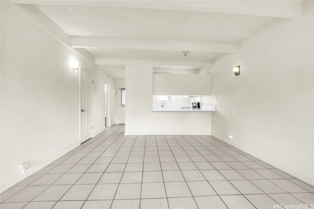 unfurnished living room with beam ceiling and light tile patterned floors