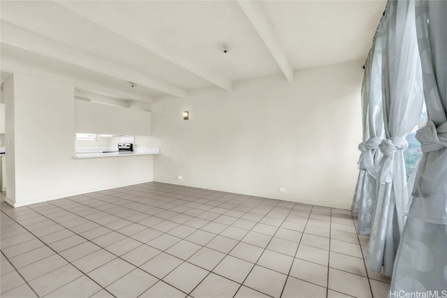 empty room featuring beamed ceiling and light tile patterned floors