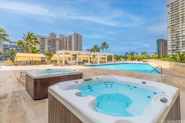 view of swimming pool with a patio and an outdoor hot tub