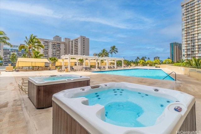 community pool with a pergola, a city view, a patio area, and a community hot tub