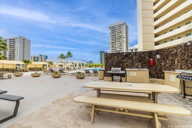 view of property's community featuring a patio area, a view of city, and a pergola
