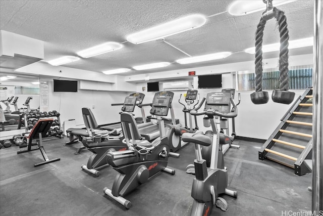 workout area featuring an AC wall unit and a textured ceiling