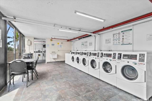 washroom with stacked washer / dryer, a textured ceiling, sink, and independent washer and dryer