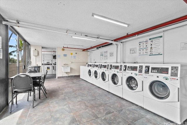 common laundry area featuring washer and clothes dryer, a textured ceiling, and stacked washer and clothes dryer