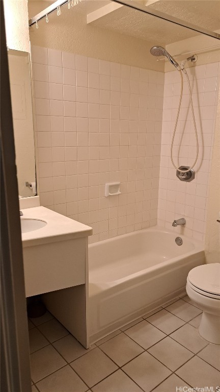 full bathroom with vanity, tiled shower / bath combo, toilet, and tile patterned flooring