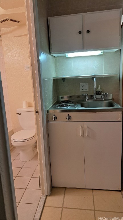 kitchen with sink, decorative backsplash, and light tile patterned flooring