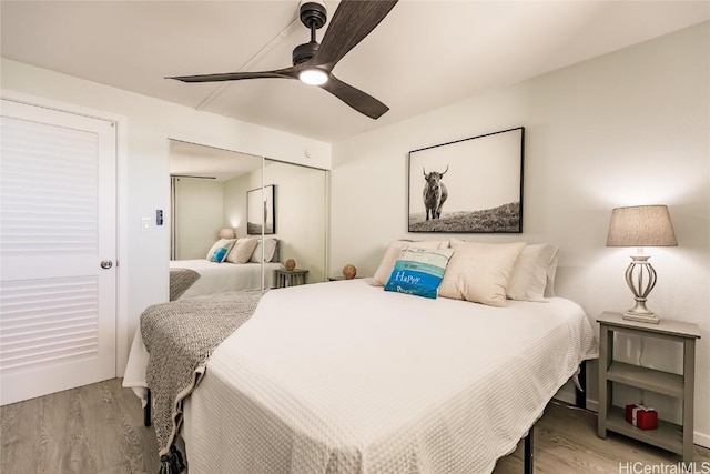 bedroom featuring a ceiling fan, wood finished floors, and a closet