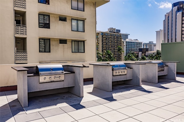 view of patio featuring a city view, exterior kitchen, and area for grilling