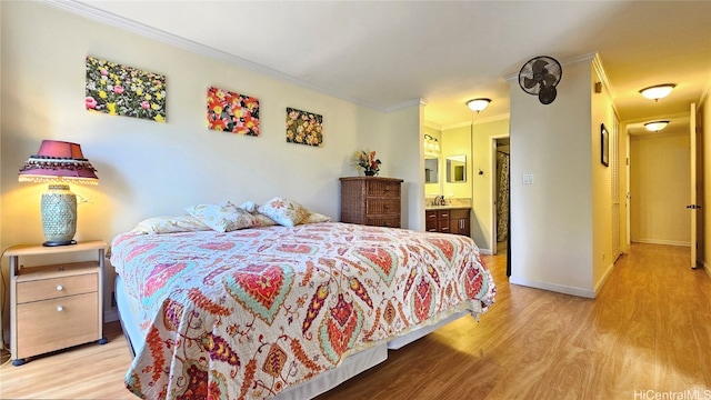 bedroom featuring connected bathroom, crown molding, and light hardwood / wood-style flooring