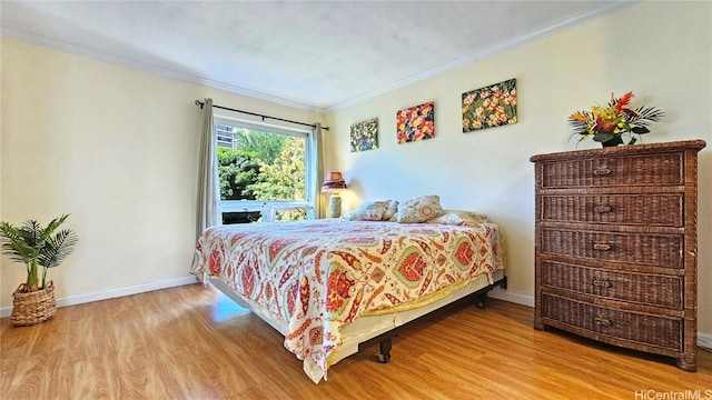 bedroom with light hardwood / wood-style flooring and ornamental molding