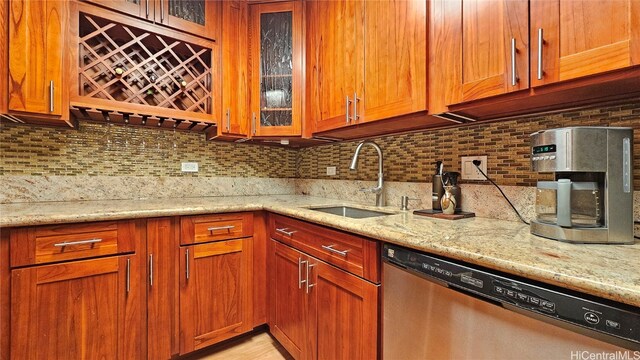 kitchen featuring dishwasher, light stone countertops, sink, and backsplash