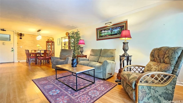 living room with crown molding and light wood-type flooring