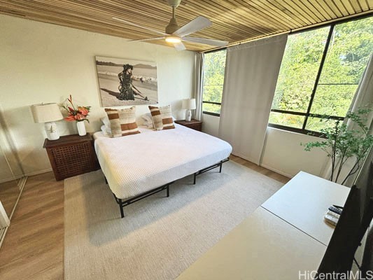 bedroom with wood ceiling, light wood-type flooring, and ceiling fan