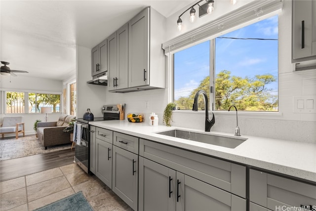 kitchen featuring gray cabinets, ceiling fan, electric stove, light hardwood / wood-style floors, and sink