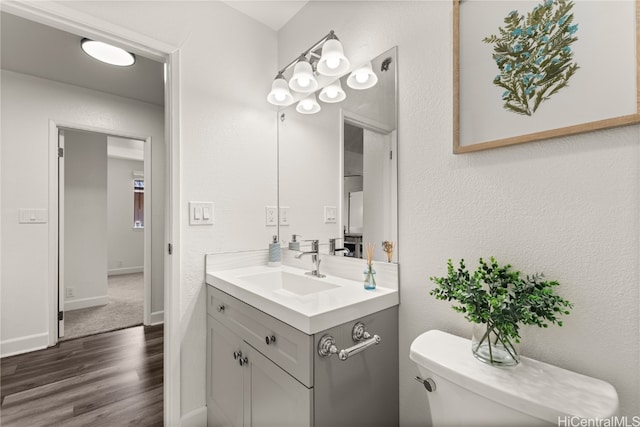 bathroom featuring toilet, hardwood / wood-style flooring, and vanity