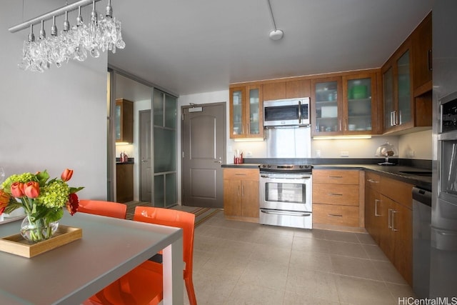 kitchen with appliances with stainless steel finishes, an inviting chandelier, and hanging light fixtures