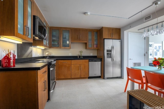 kitchen with sink, appliances with stainless steel finishes, and decorative light fixtures