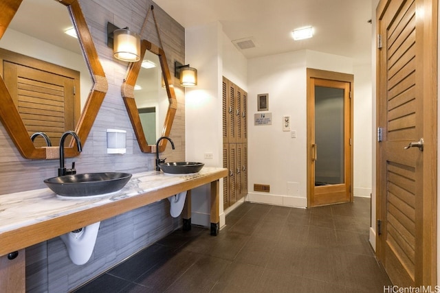 bathroom featuring tile patterned floors, sink, and decorative backsplash