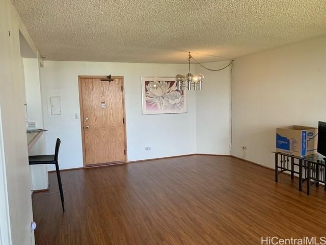5333 Likini St Unit 2103, Honolulu, HI 96818 - unfurnished dining area featuring wood finished floors, a chandelier, and a textured ceiling