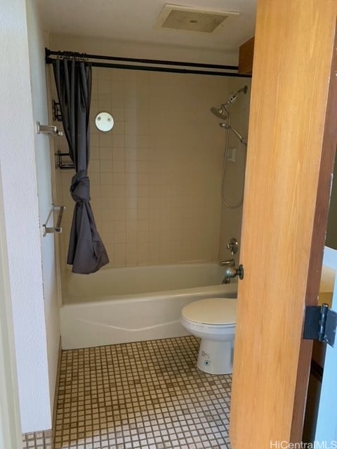 bathroom featuring tile patterned floors, shower / tub combo with curtain, and toilet