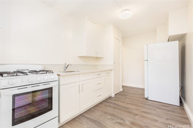 kitchen featuring white appliances, white cabinetry, sink, and light wood-type flooring