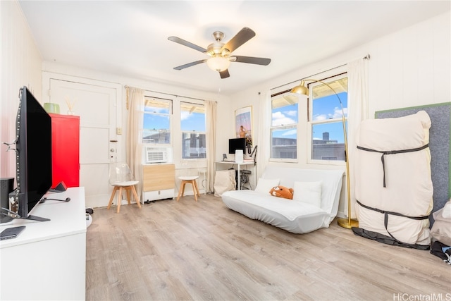 sitting room featuring cooling unit, light hardwood / wood-style floors, and ceiling fan