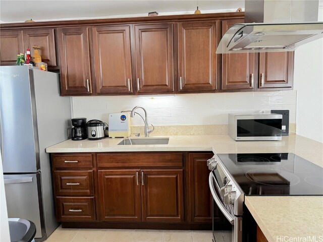 kitchen featuring under cabinet range hood, stainless steel appliances, a sink, light countertops, and backsplash