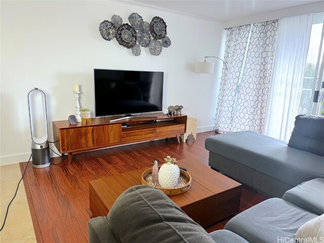 living area with baseboards and wood finished floors