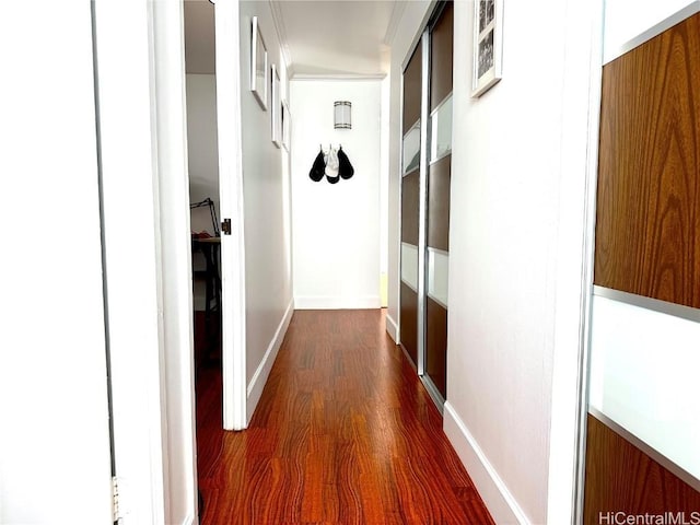 corridor featuring dark wood-type flooring and baseboards