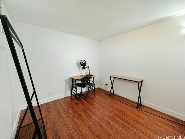 interior space with baseboards and wood finished floors