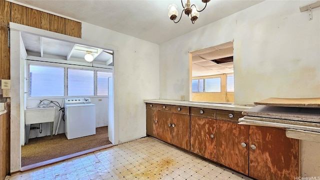 interior space featuring light floors, washer / dryer, a notable chandelier, and light countertops